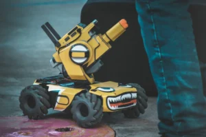 Small robotic tank with a cartoonish design and a cannon, showcasing engineering creativity in robotics education at Flatline Robotics.